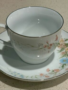 White Porcelain Teacup and Saucer with Pastel Floral Design and Gold Trim